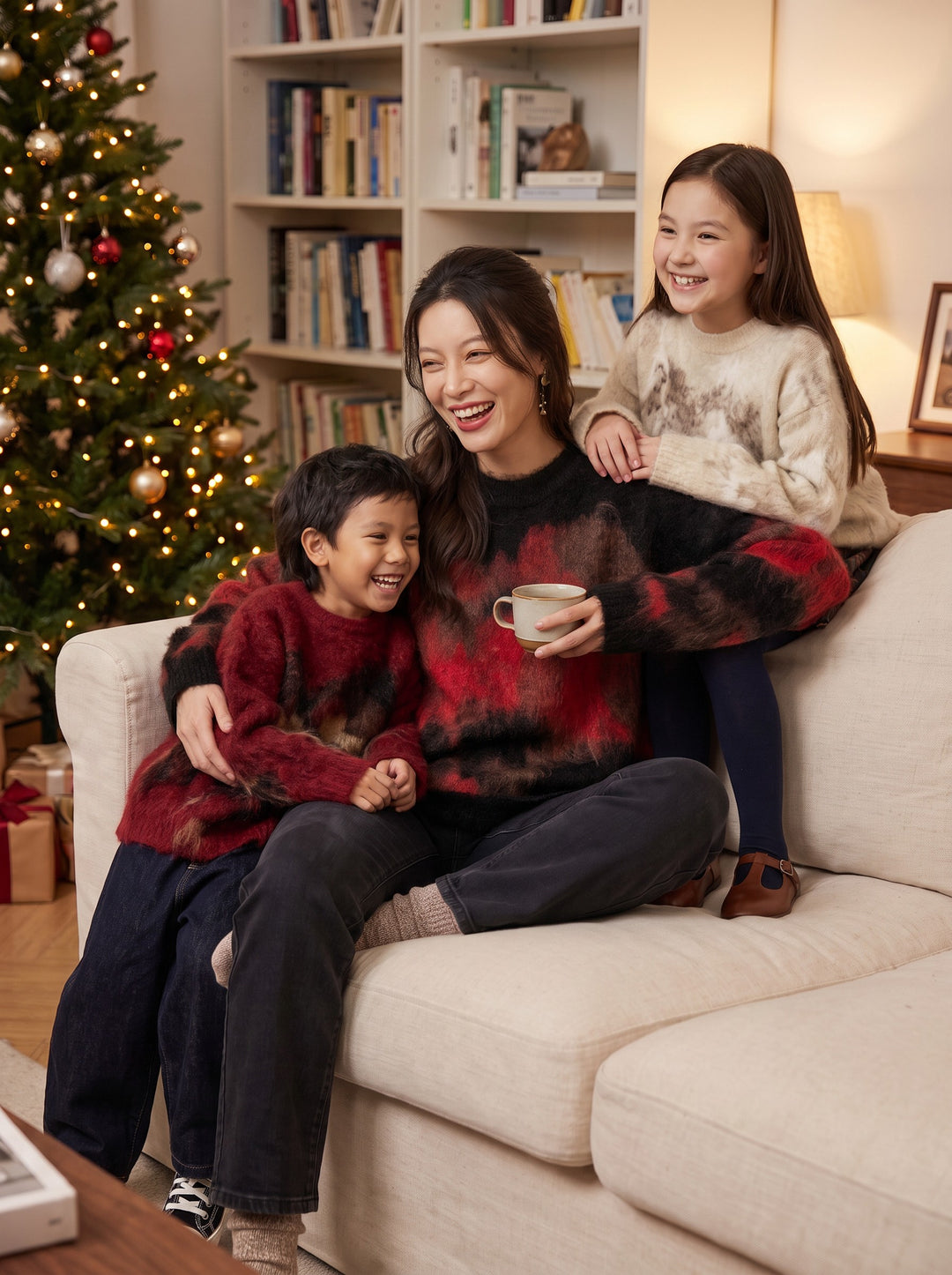 Xu Beihong Galloping Horse Family Sweater 徐悲鸿联名大展鸿图毛衣 – mom in Black 河豚黑 with kids in Red 年衣红 and Ivory 汉玉白 at home